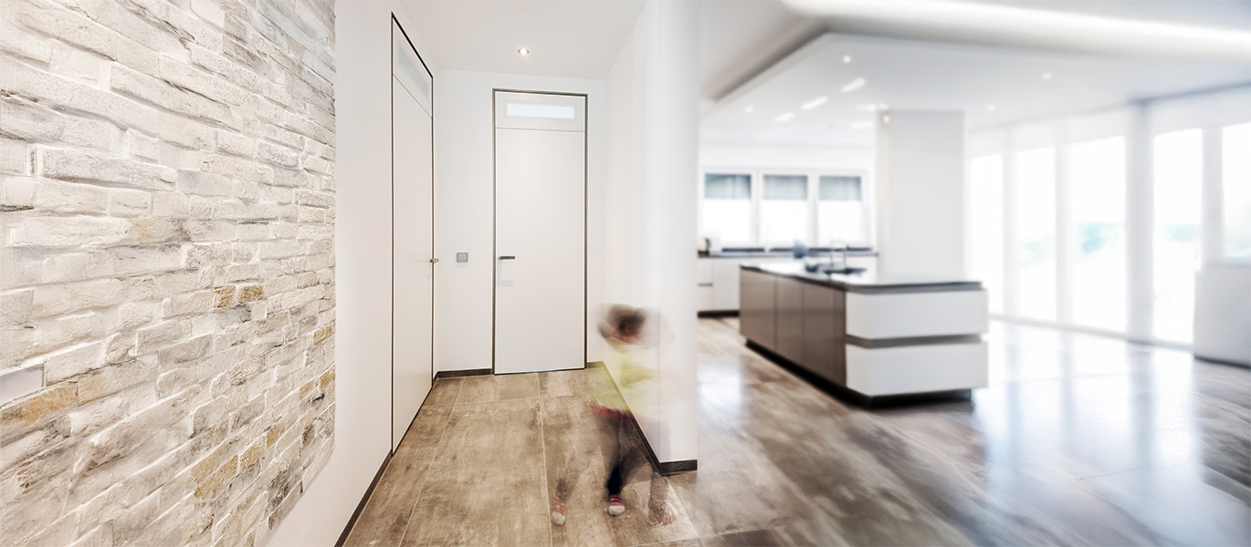 große, helle und moderne Wohnküche-mit Holzakzenten. Im Fokus die wandbündige Tür modulWERK 2.0